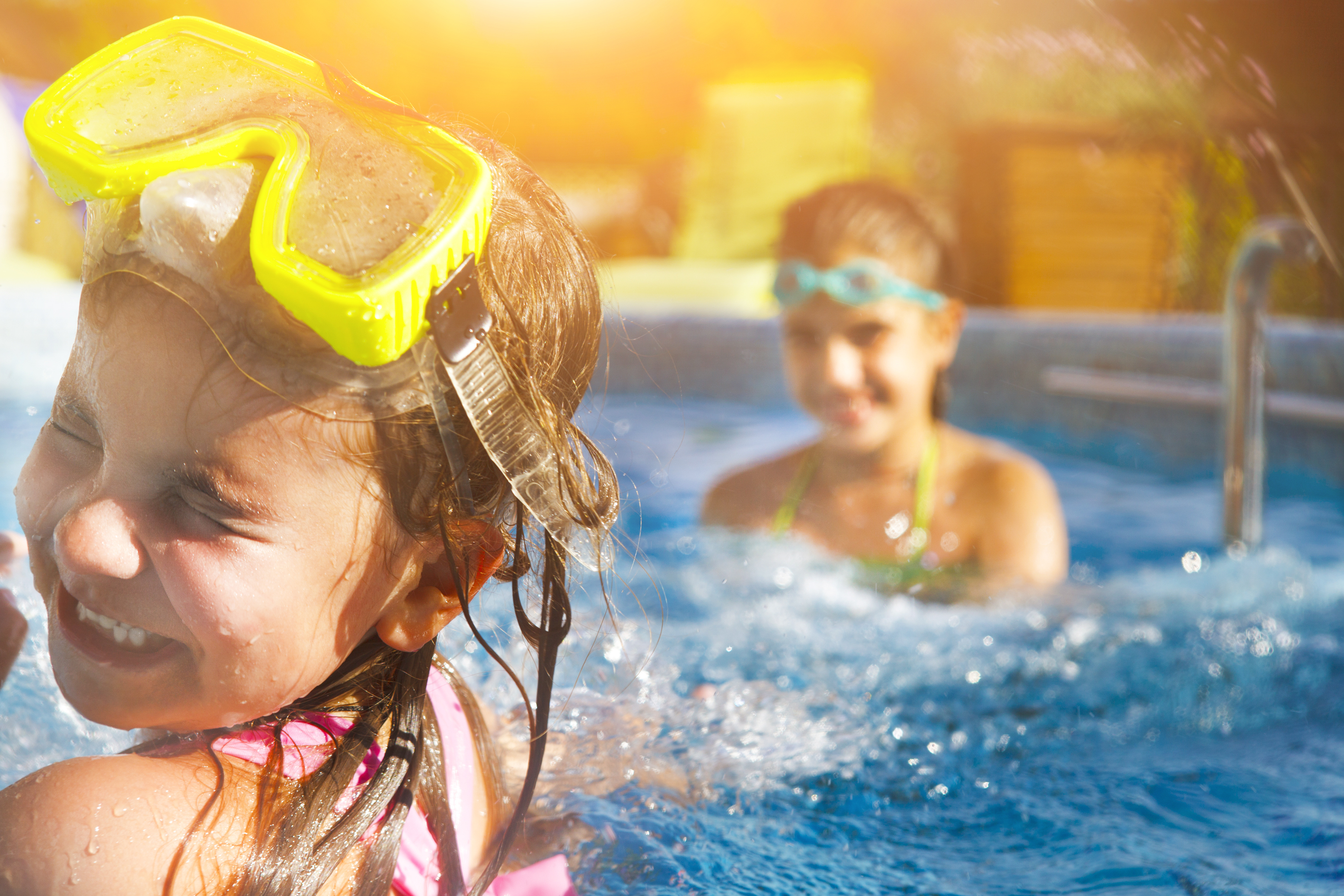 children wearing goggles having fun in the pool