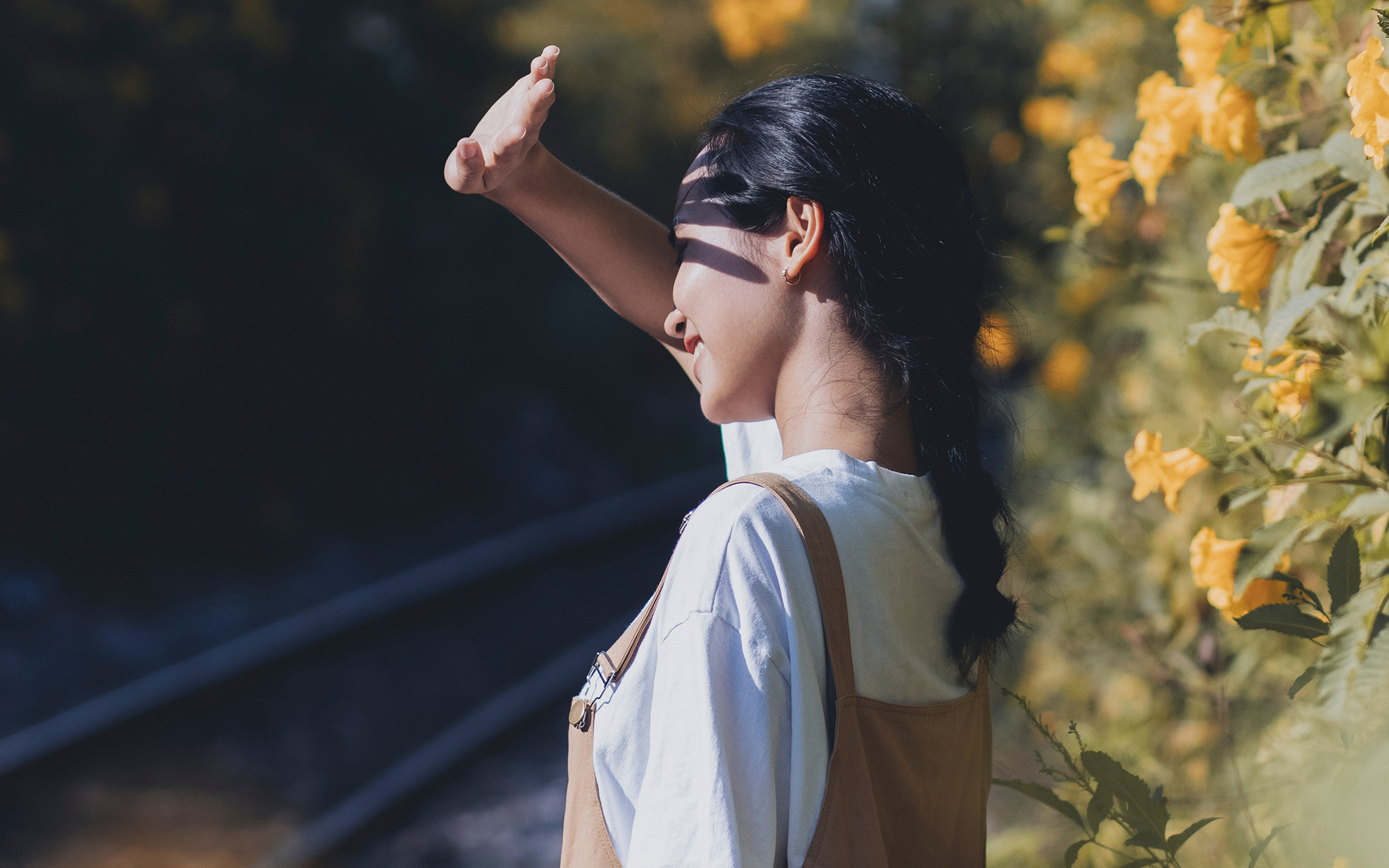woman raising a hand to shield eyes against sun